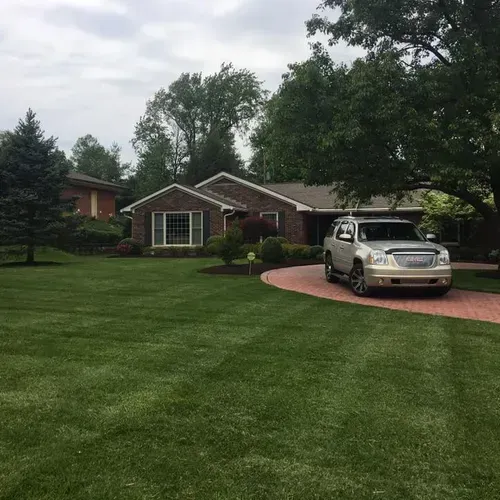 A car is parked in a driveway in front of a house.