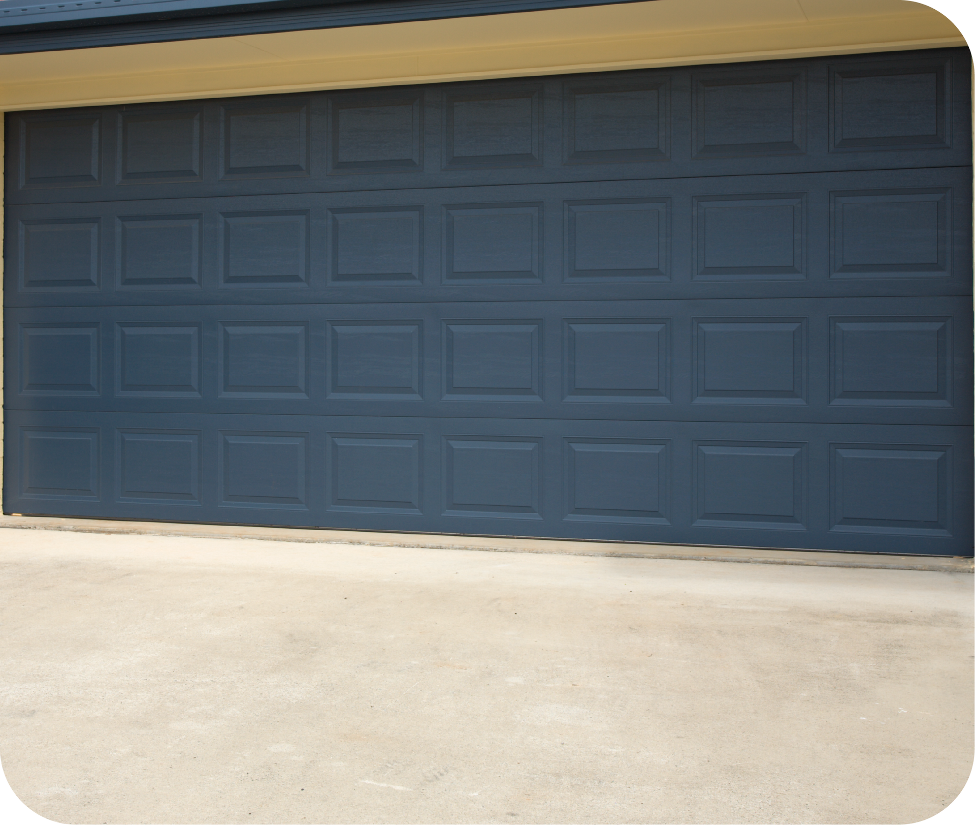 A dark blue, four-panel residential garage door with a rectangular grid pattern, viewed from a concrete driveway.