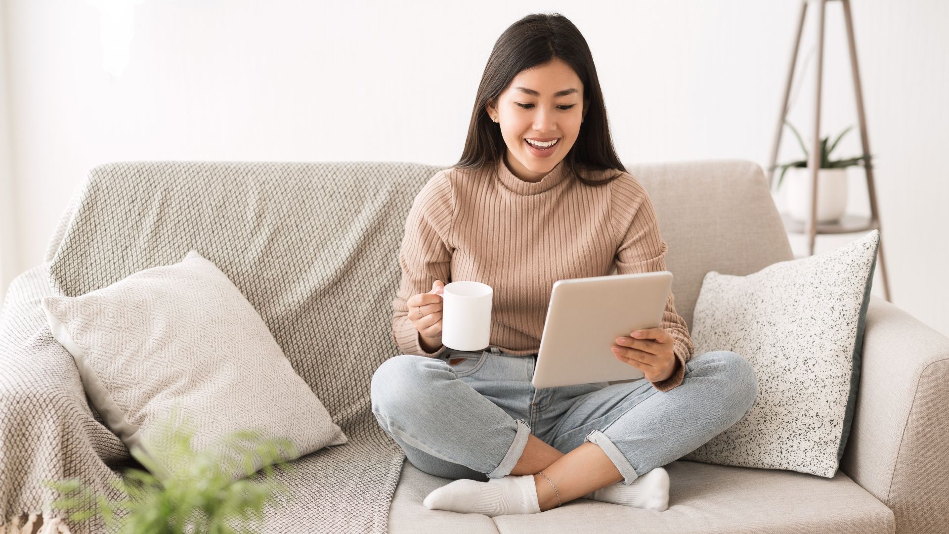 Woman sitting on sofa reading SEO-Friendly Content on her tablet computer
