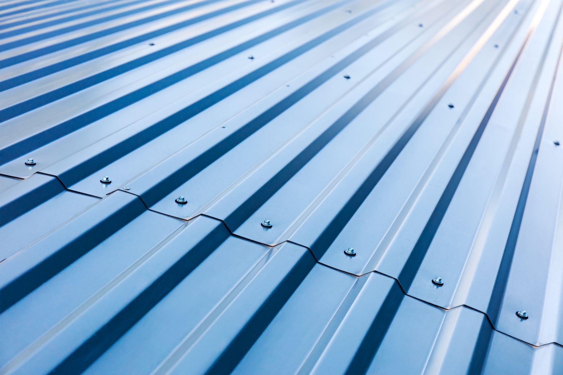 Close up of corrugated metal panels with evenly spaced screws along each ridge.