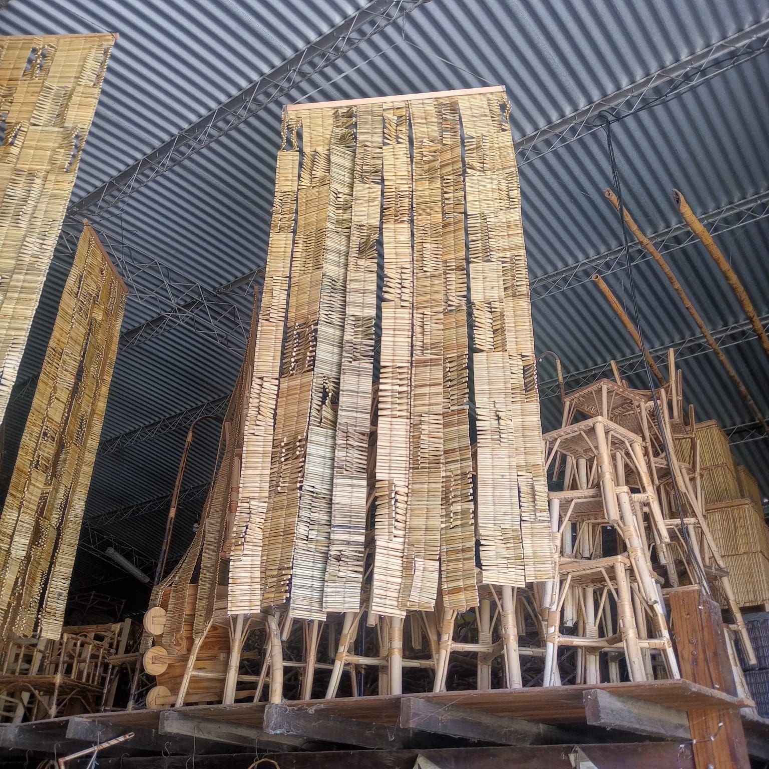 Grandes esteras de junco tejidas cuelgan verticalmente en un taller