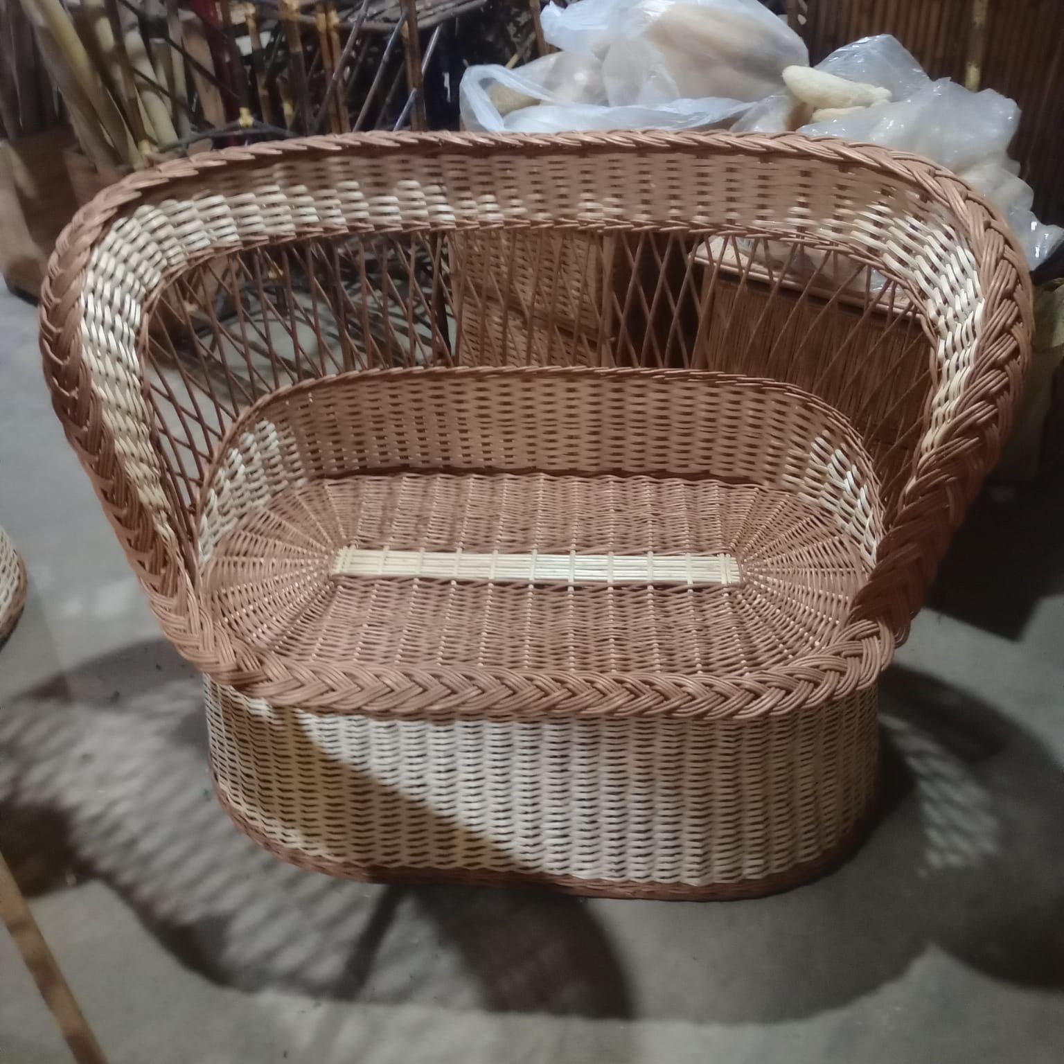 Un pequeño sofá redondo de mimbre o cama para mascotas