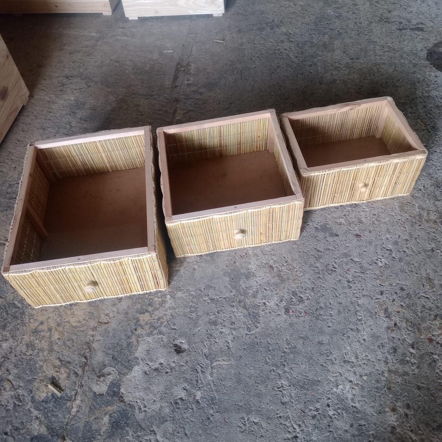Tres cajones rectangulares abiertos con frentes de textura de mimbre marrón