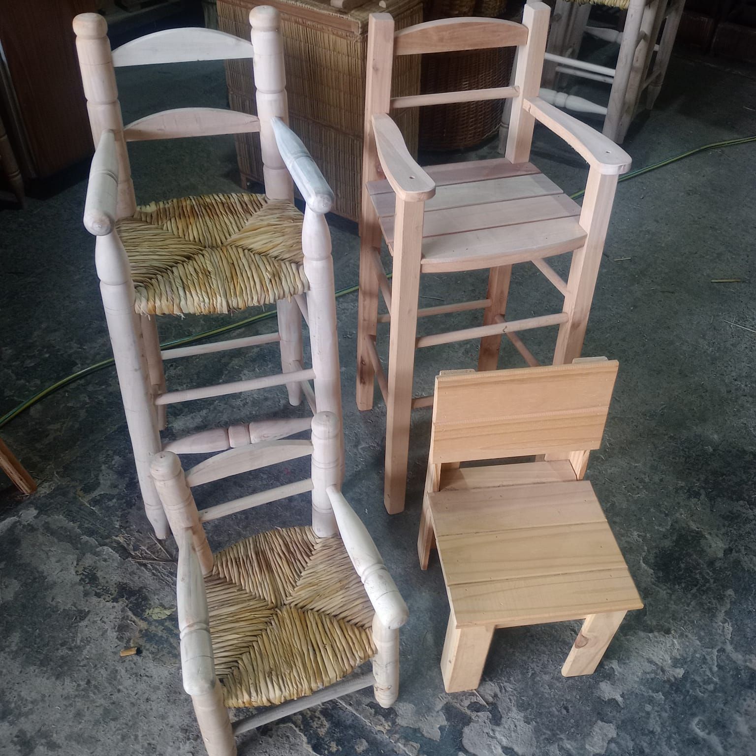 Cuatro sillas de madera clara, dos con asientos de junco tejido