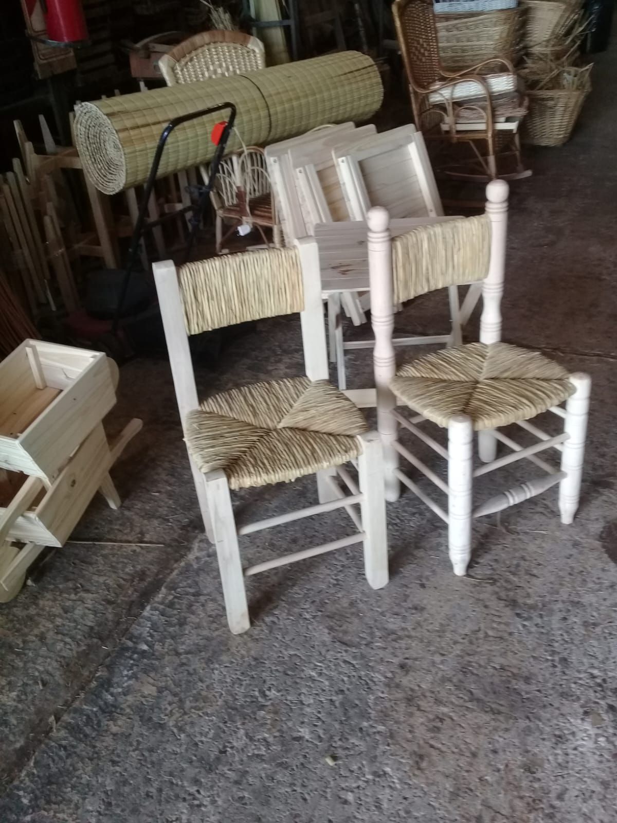 Dos sillas de madera clara con asientos y respaldos de paja tejida