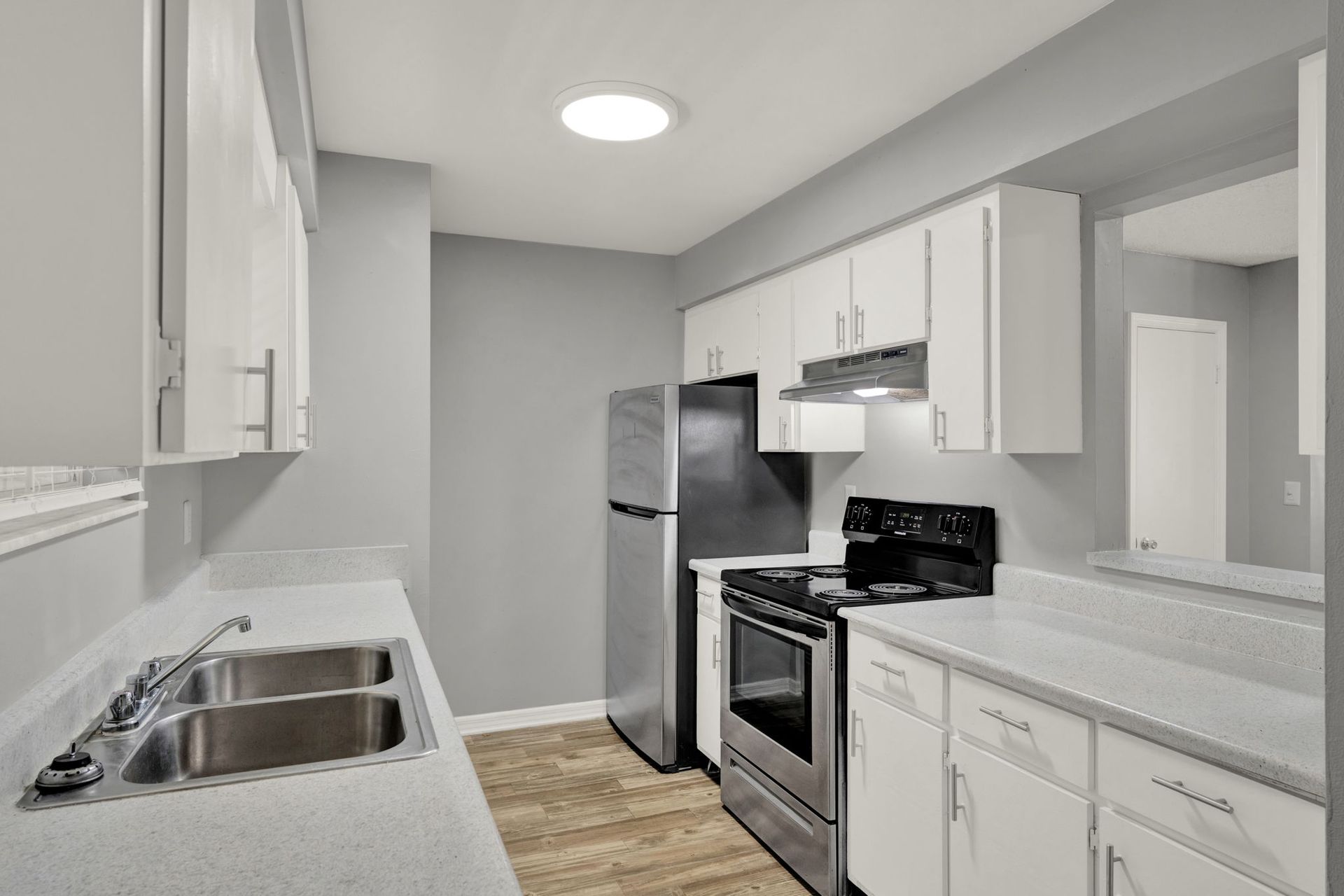 Kitchen with white cabinets, stainless steel appliances, and gray walls.