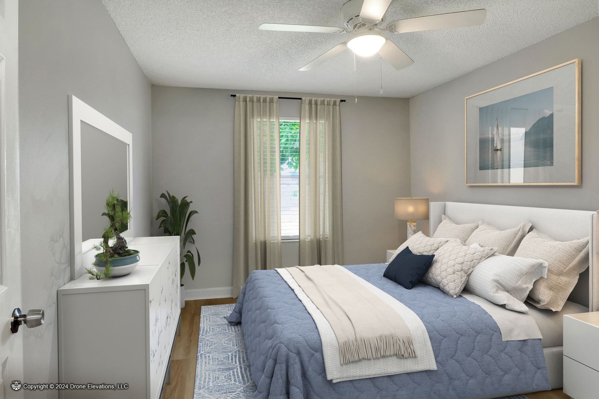 Bedroom with a bed, dresser, window, and artwork. Gray walls, blue bedding, and white furniture.