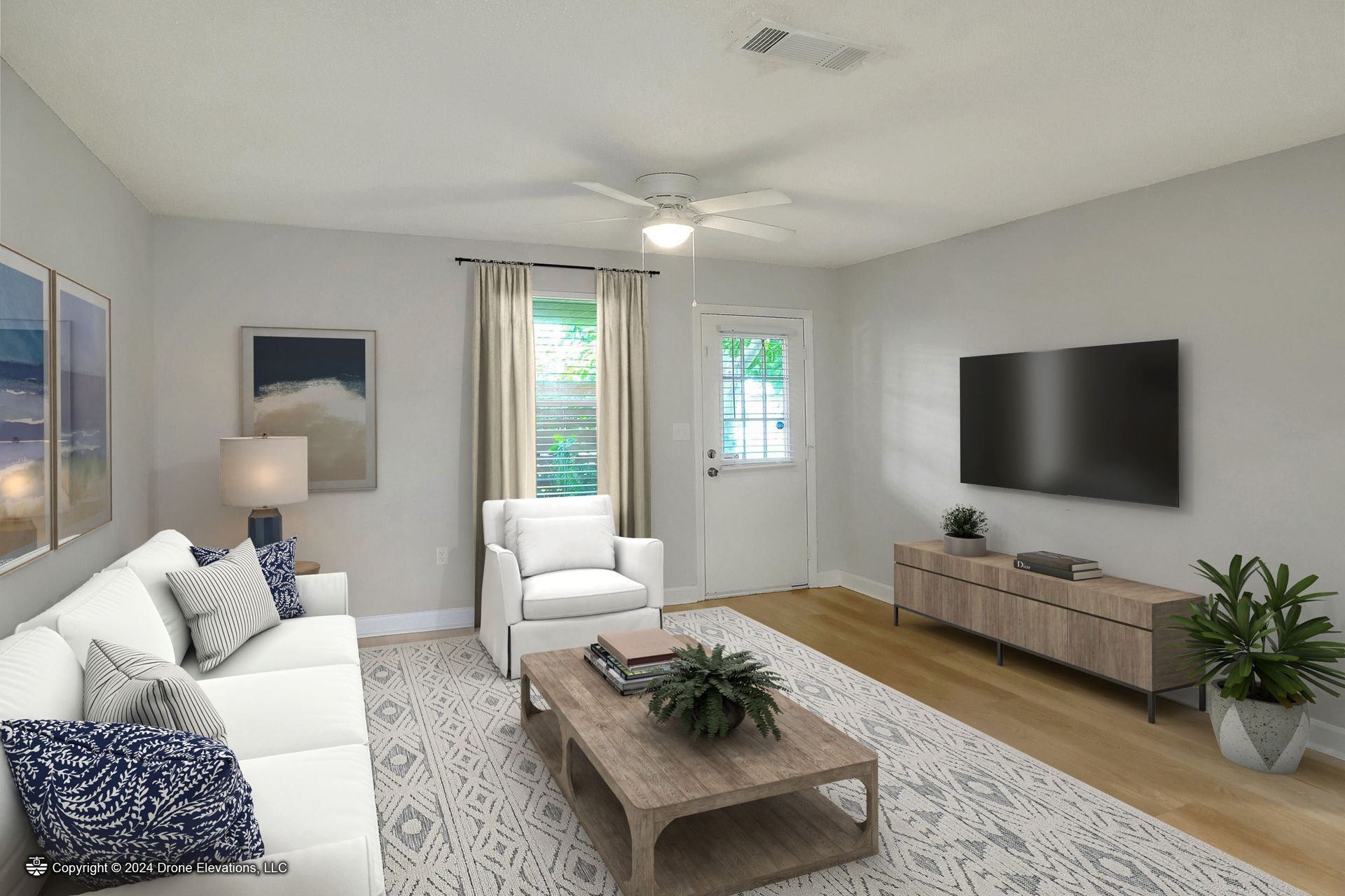 Living room with white couch, TV, and wood coffee table.