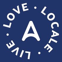White “LOVE LOCAL” circular logo on a dark blue background with a central stylized white A.