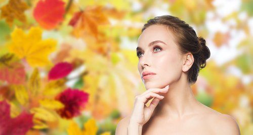 woman gazing into the distance in front of a floral back drop