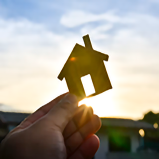 A person is holding a small house in their hand.