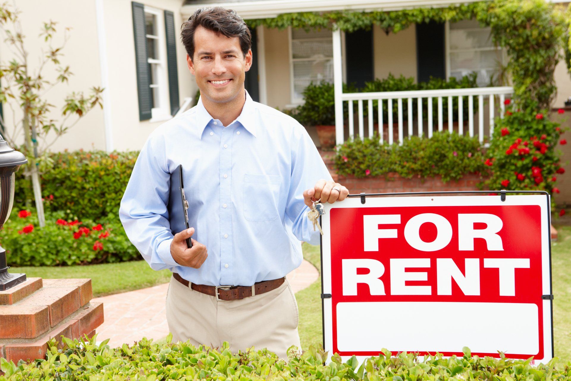 man in front of for rent sign