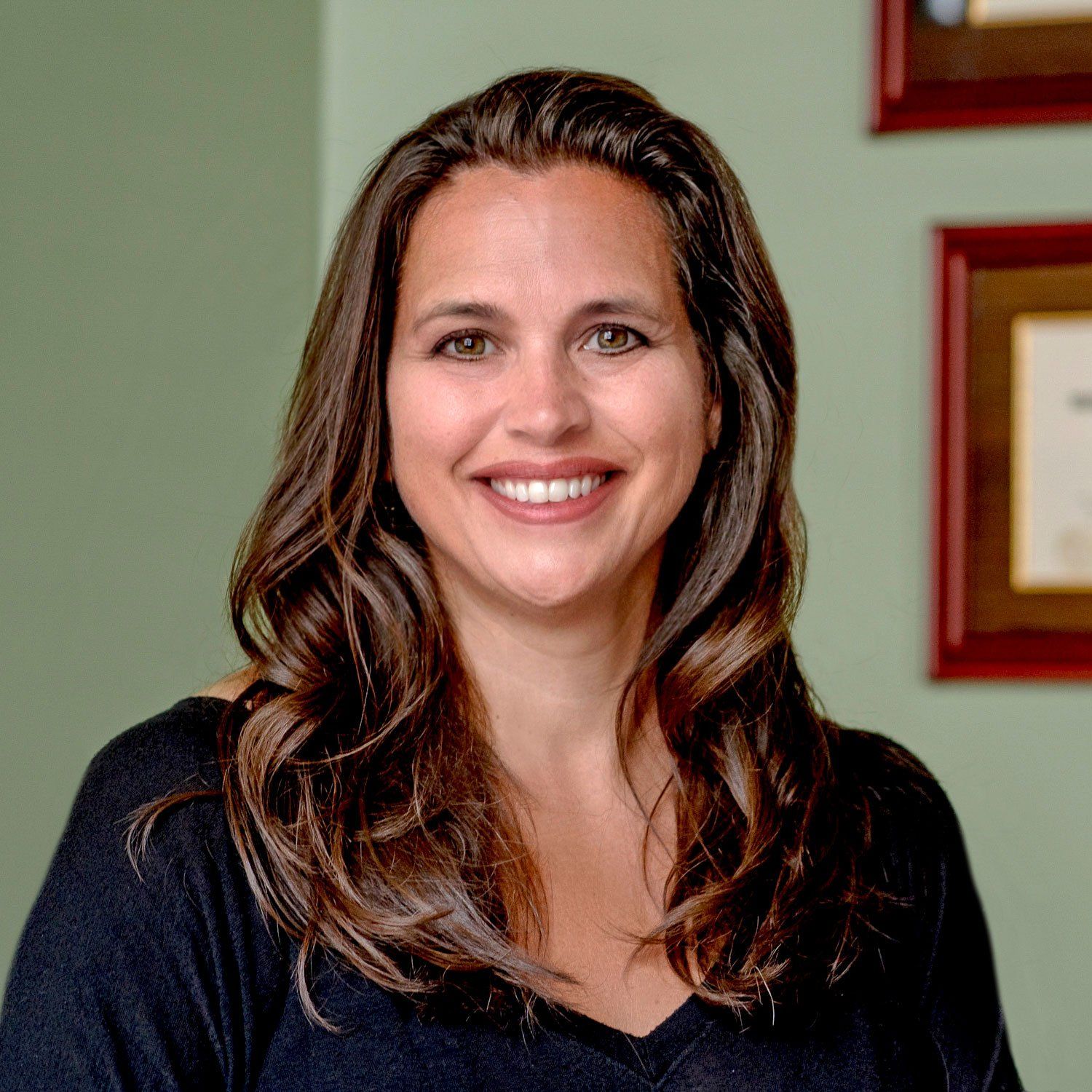 A woman in a black shirt is smiling for the camera