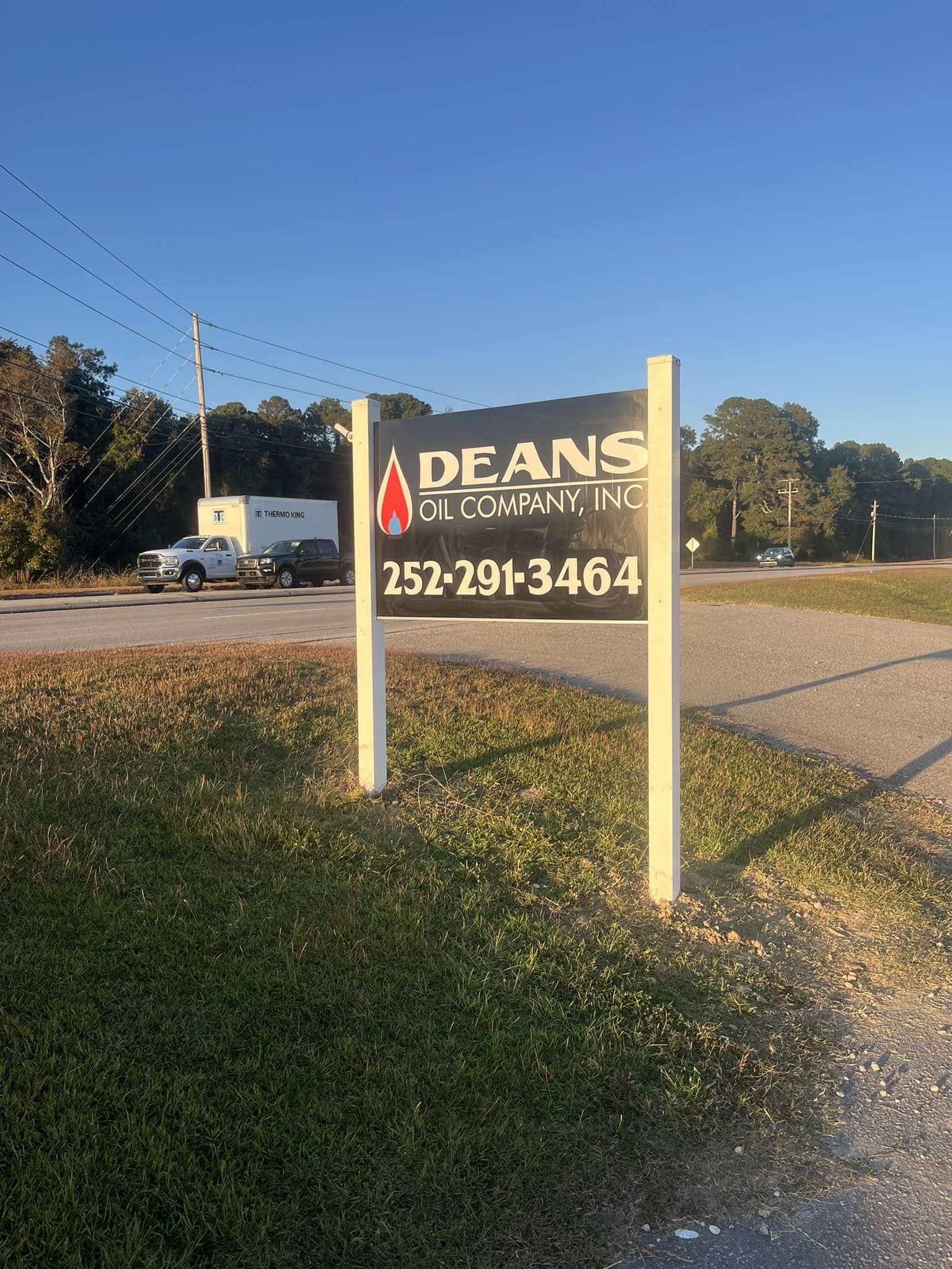 Sign for Dean's Plumbing Inc. with phone number 252-291-3464, on a sunny day.