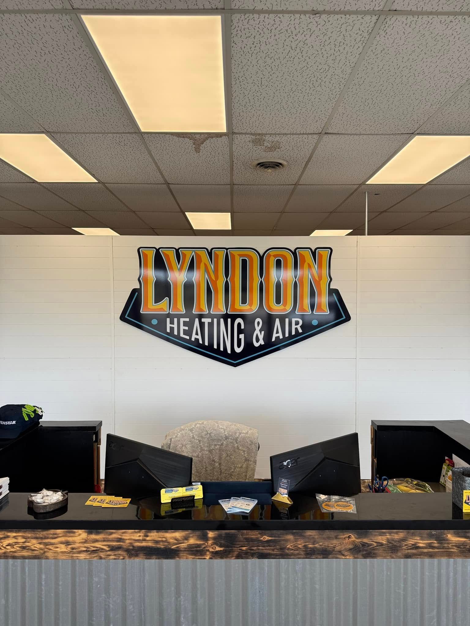 Lyndon Heating & Air logo above a black counter with brochures and items.
