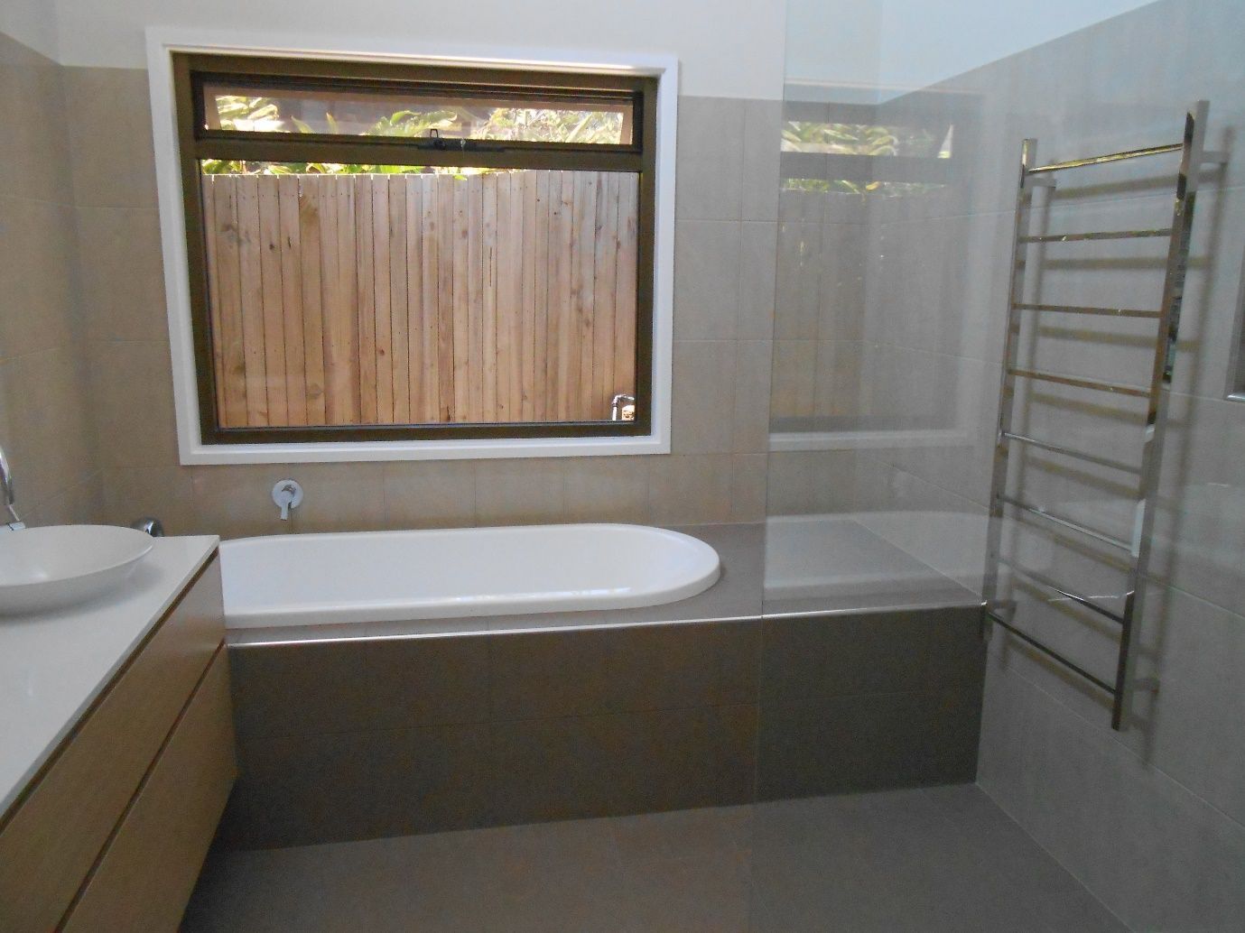 A Bathroom With a Bathtub a Sink and a Window  — Scott Graham Building Services In Bilambil Heights, NSW 