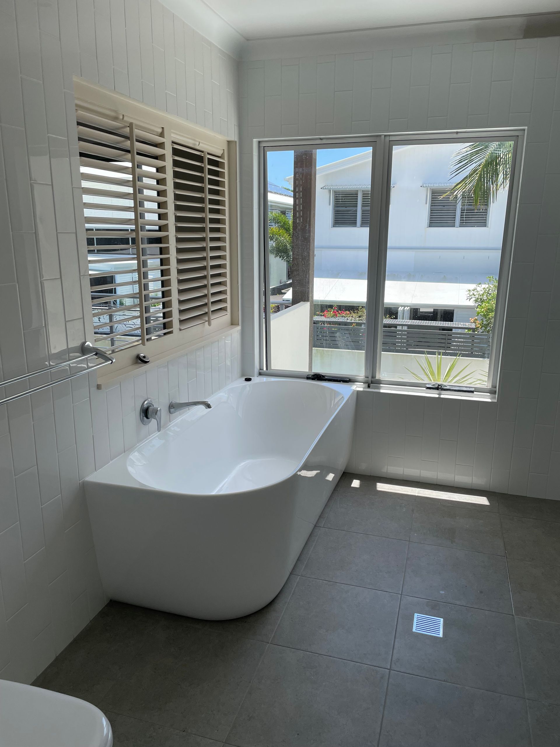 A Bathroom With Two Mirrors And A Tub  — Scott Graham Building Services In Bilambil Heights, NSW