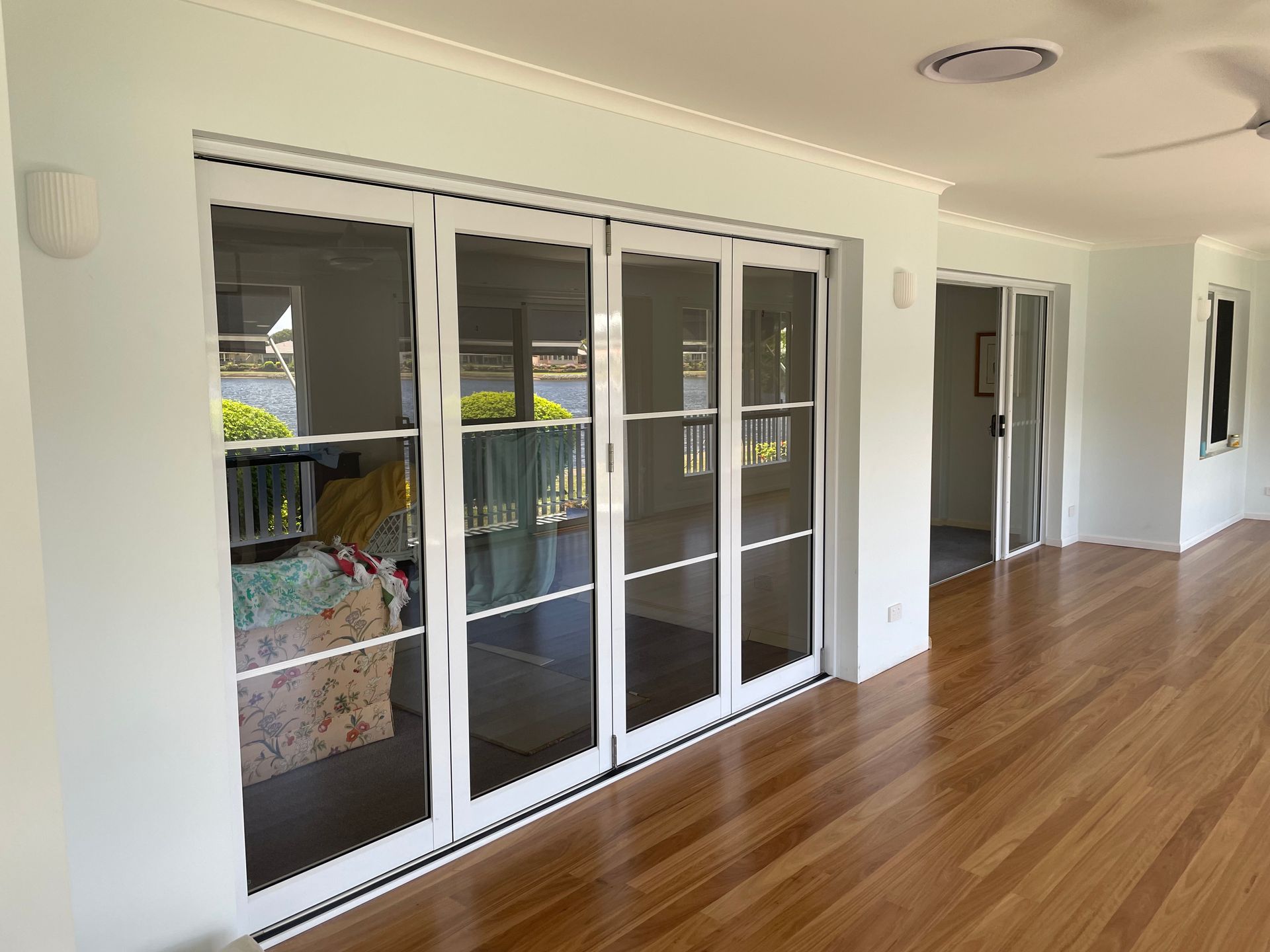 A Person Is Painting A Wooden Wall With A Brush — Scott Graham Building Services In Palm Beach, NSW