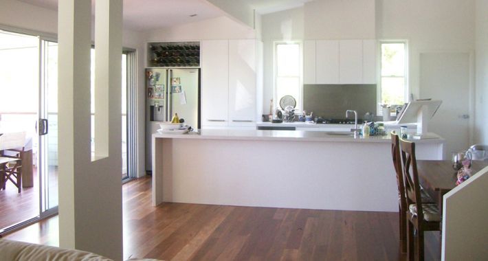 A Kitchen With White Cabinets and a Large Island in the Middle of the Room  — Scott Graham Building Services In Bilambil Heights, NSW 