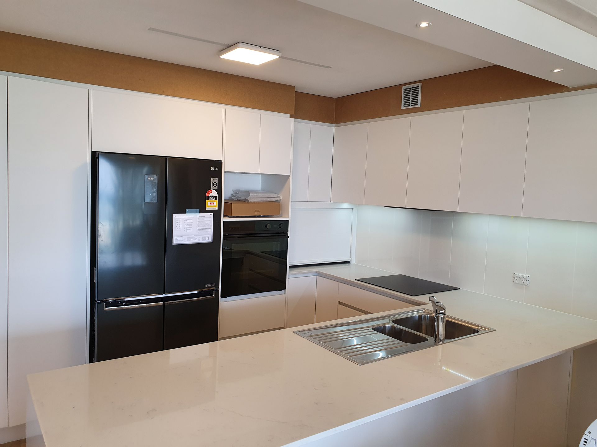 A Modern Kitchen With Wooden Cabinets And White Counter Tops — Scott Graham Building Services In Bilambil Heights, NSW 