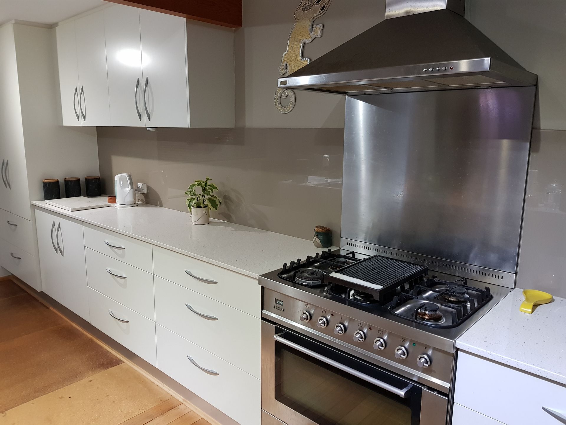 A Person Is Painting A Wooden Deck With A Brush — Scott Graham Building Services In Burleigh Heads, QLD