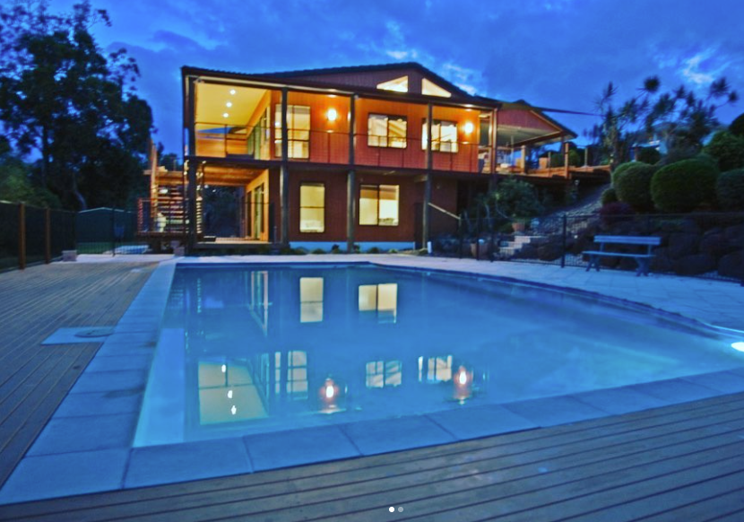 A large house with a swimming pool in front of it