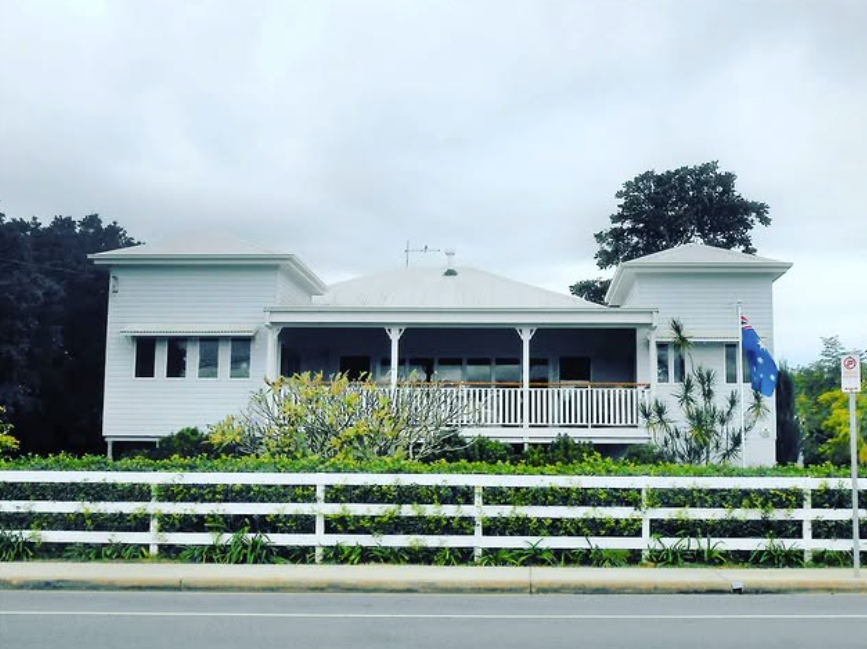 A large white house with a white fence around it