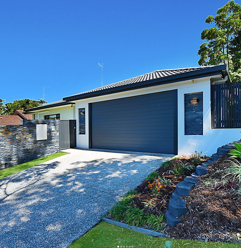 A white house with a black garage door