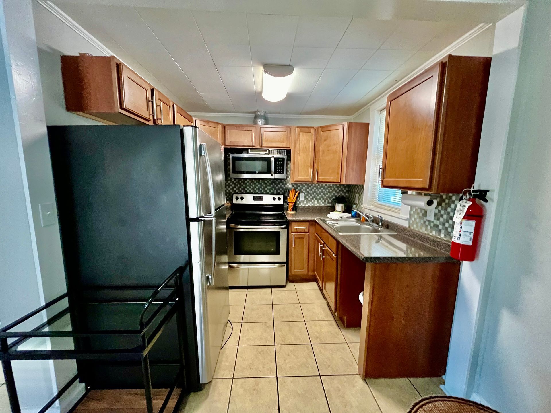 A fully equipped kitchen at Seabirds Motel at Kure Beach, featuring modern stainless steel appliances, wooden cabinetry, and granite countertops. This kitchen is perfect for guests looking to cook their own meals while enjoying a pet-friendly lodging experience in North Carolina.