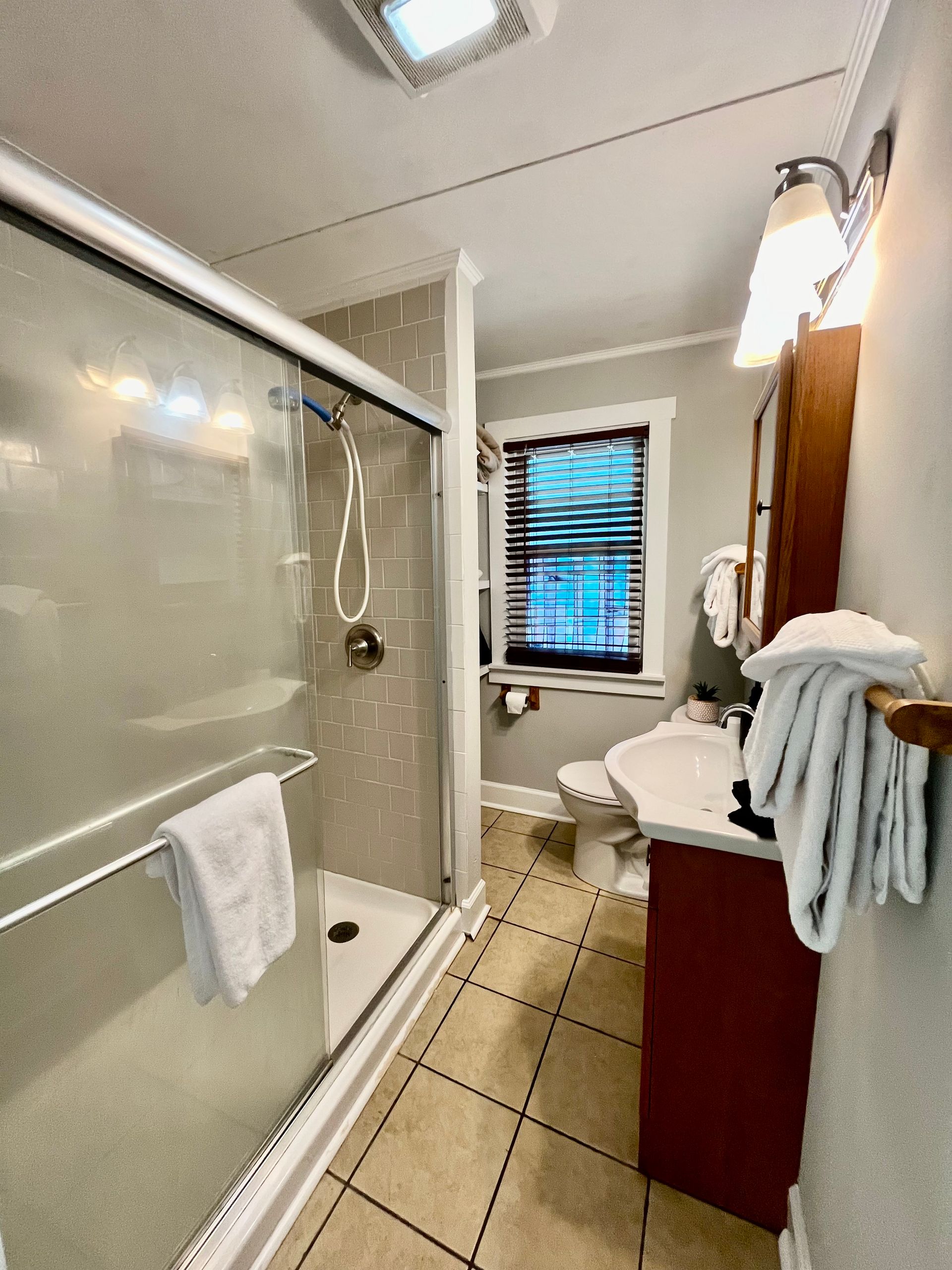 A modern bathroom at Seabirds Motel at Kure Beach with a shower-tub combo, vanity sink, and fresh towels. The bathroom is designed to provide all necessary amenities, ensuring a comfortable and pet-friendly stay in North Carolina.