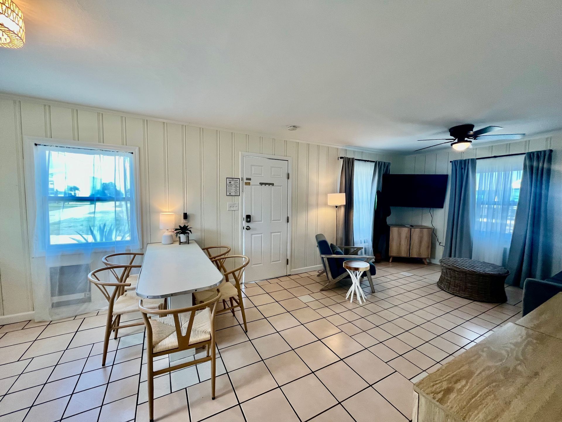 A spacious living room at Seabirds Motel at Kure Beach featuring a large flat-screen TV and comfortable seating. The room provides a relaxing environment, ideal for a pet-friendly stay in North Carolina.