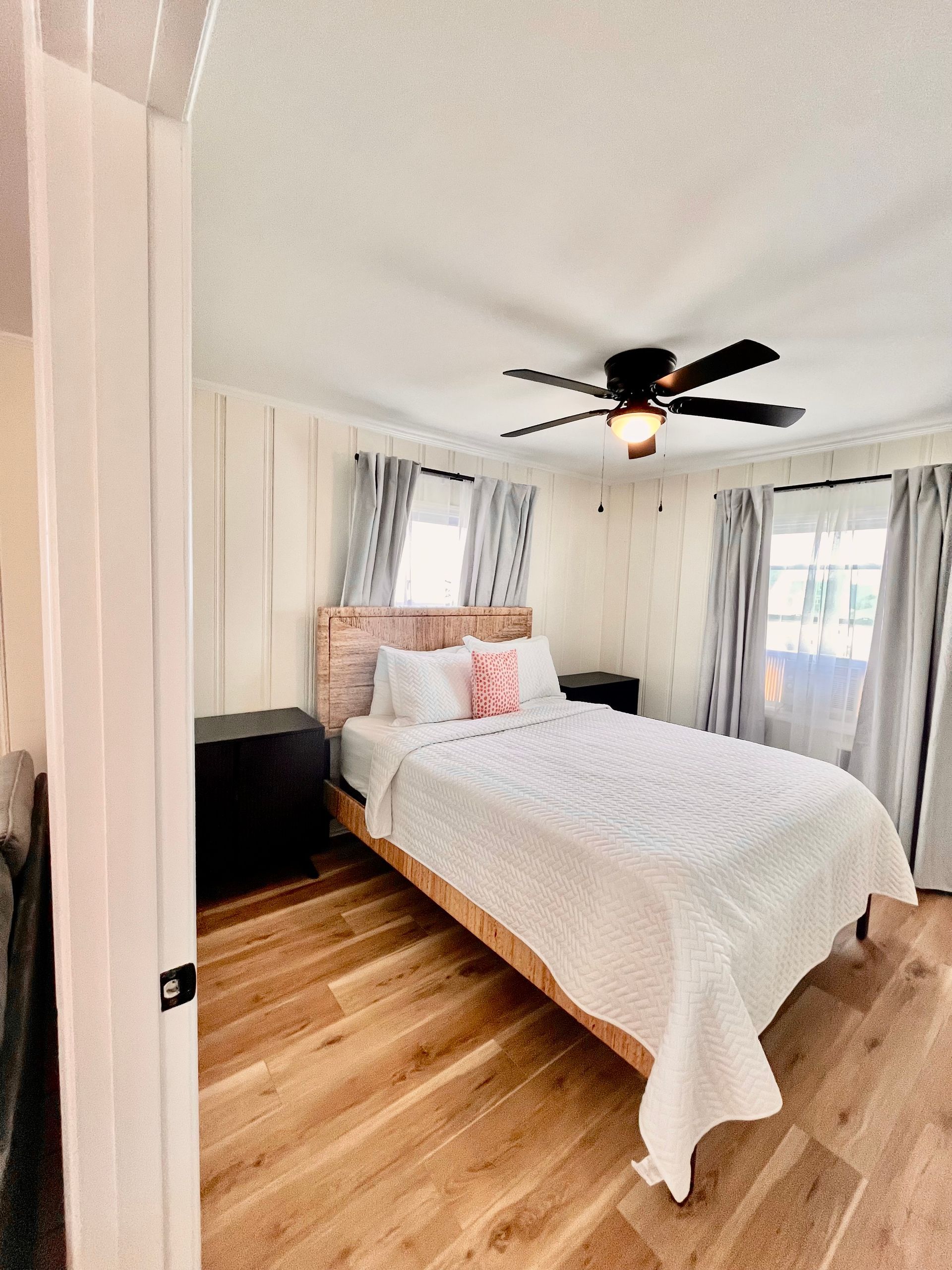 A cozy bedroom at Seabirds Motel at Kure Beach with a queen-sized bed, white bedding, and soft lighting. This room provides a warm and inviting space for a relaxing, pet-friendly stay in North Carolina.