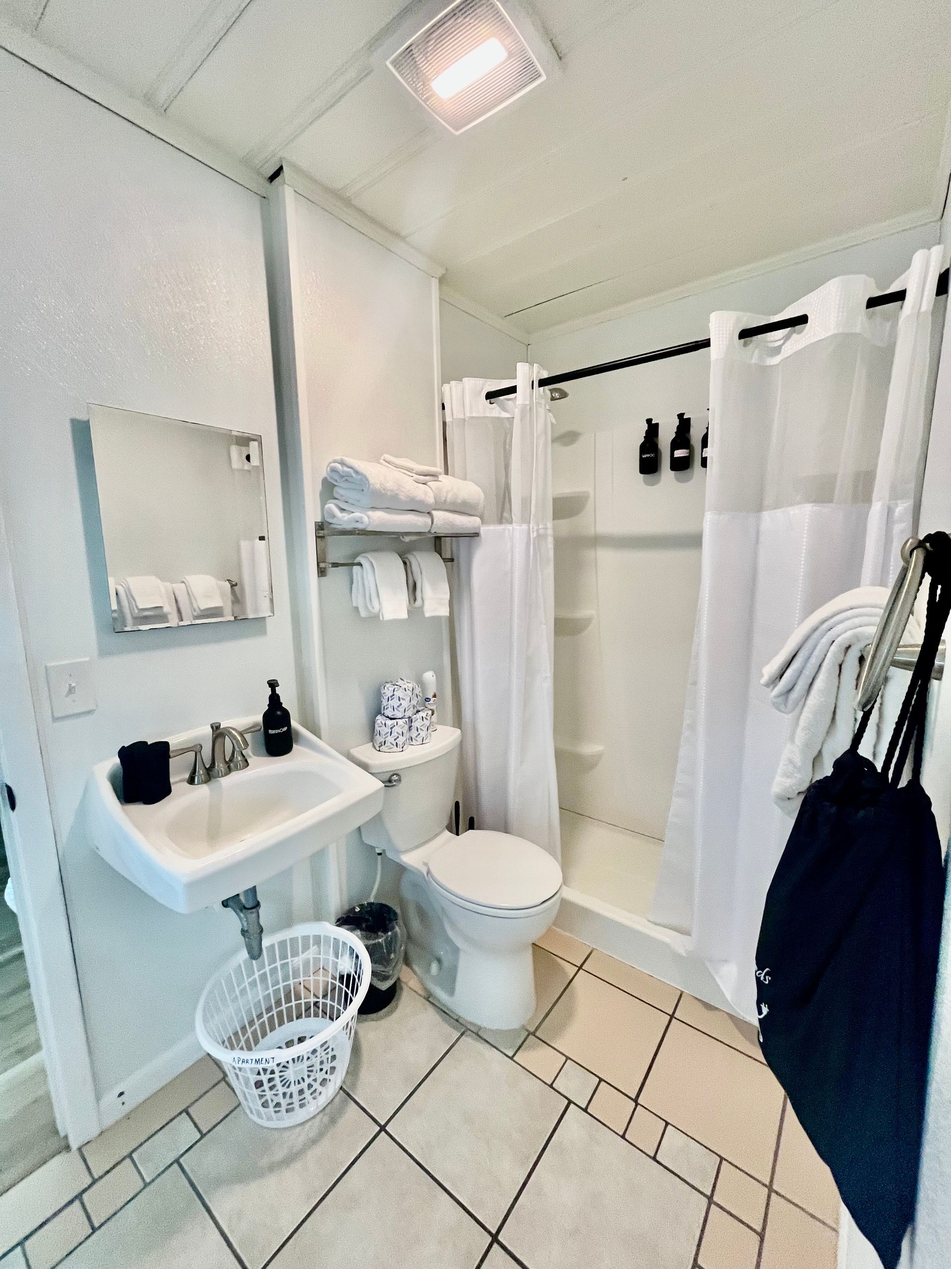 A clean and modern bathroom at Seabirds Motel at Kure Beach with a shower, vanity, and fresh towels. The bathroom provides all necessary amenities for a comfortable, pet-friendly stay in North Carolina.