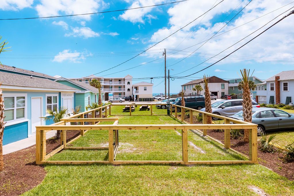 A spacious, fenced-in outdoor area at Seabirds Motel at Kure Beach designed for pets to play safely. This pet-friendly space provides a welcoming environment for guests traveling with their pets, reflecting the motel's pet policy and commitment to a pet-friendly North Carolina lodging experience.