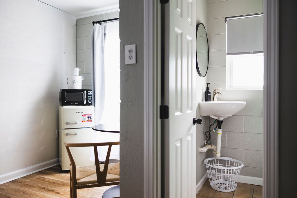 A kitchenette at Seabirds Motel at Kure Beach with a retro refrigerator, microwave, and granite countertops. This compact kitchen provides all the essentials for guests to prepare meals during their pet-friendly North Carolina lodging experience.