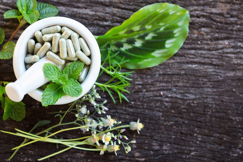 Alternative Health Care Fresh Herbal Plant And Herbal Capsule In White Mortar — Julie Taylor Naturopath in Hervey Bay, QLD