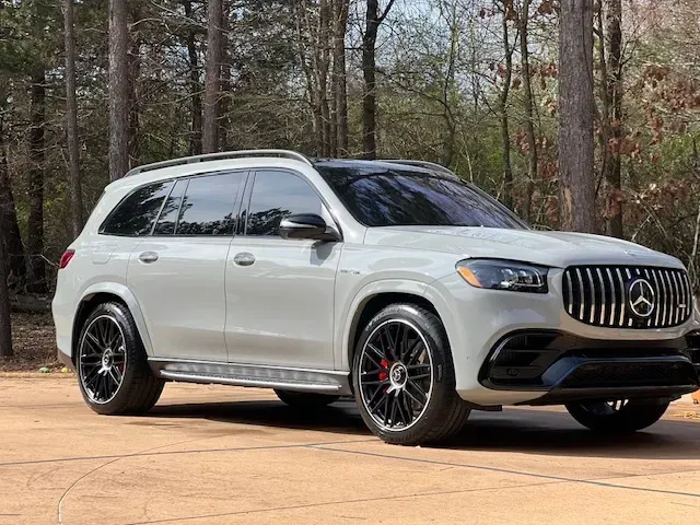 Silver Mercedes-Benz SUV parked on a dirt road in a wooded area