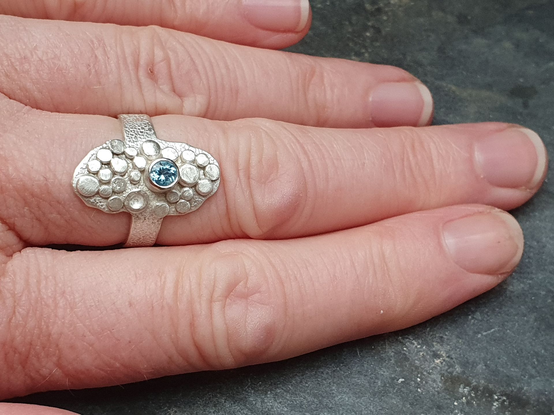 Ring with granules and blue topaz