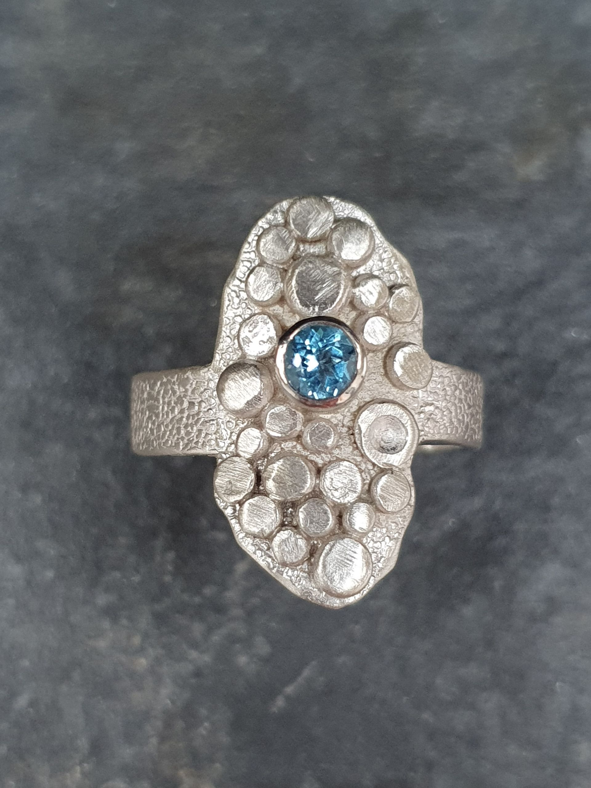 Ring with granules and blue topaz