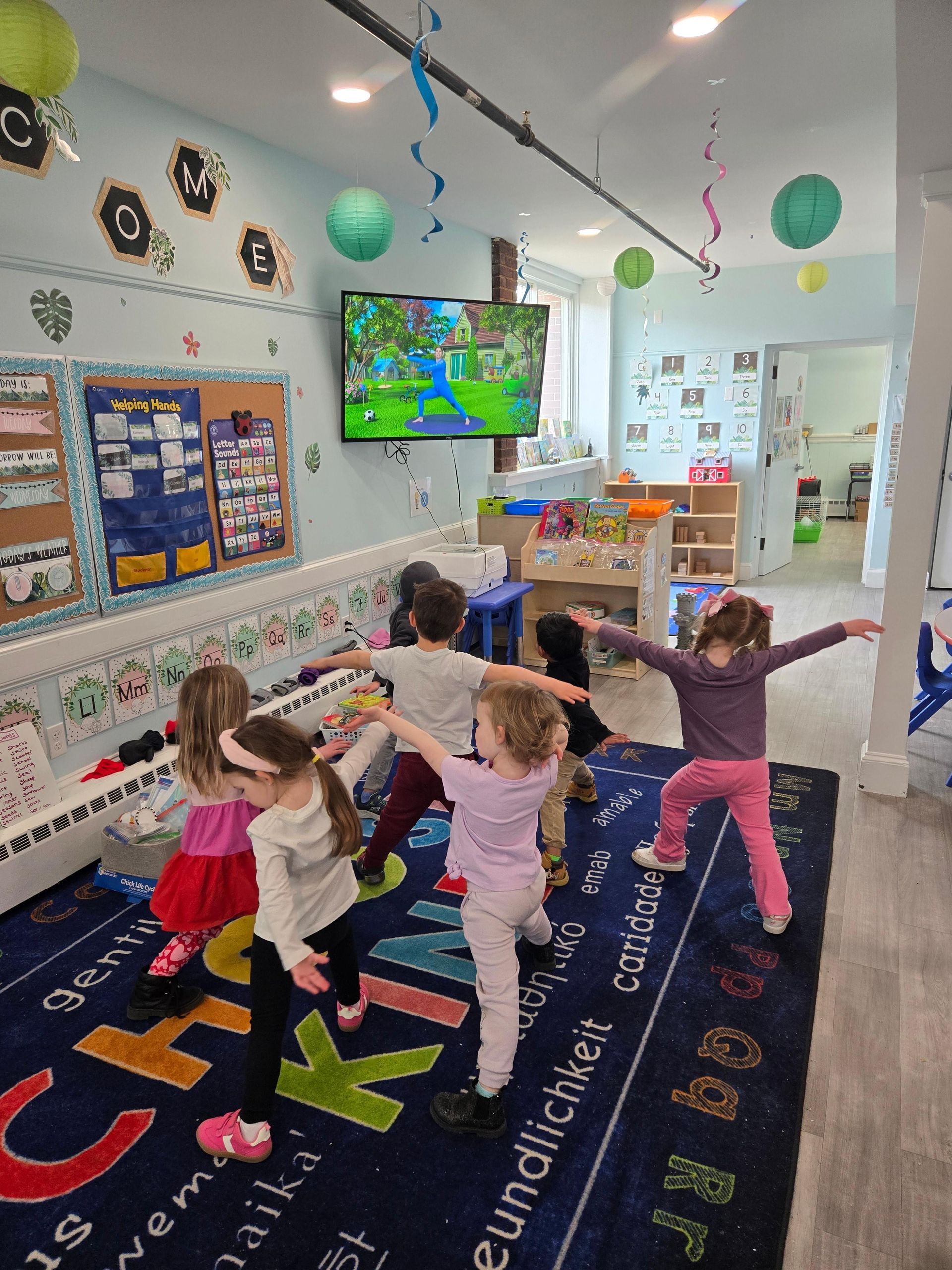 A group of children are doing yoga in a classroom.