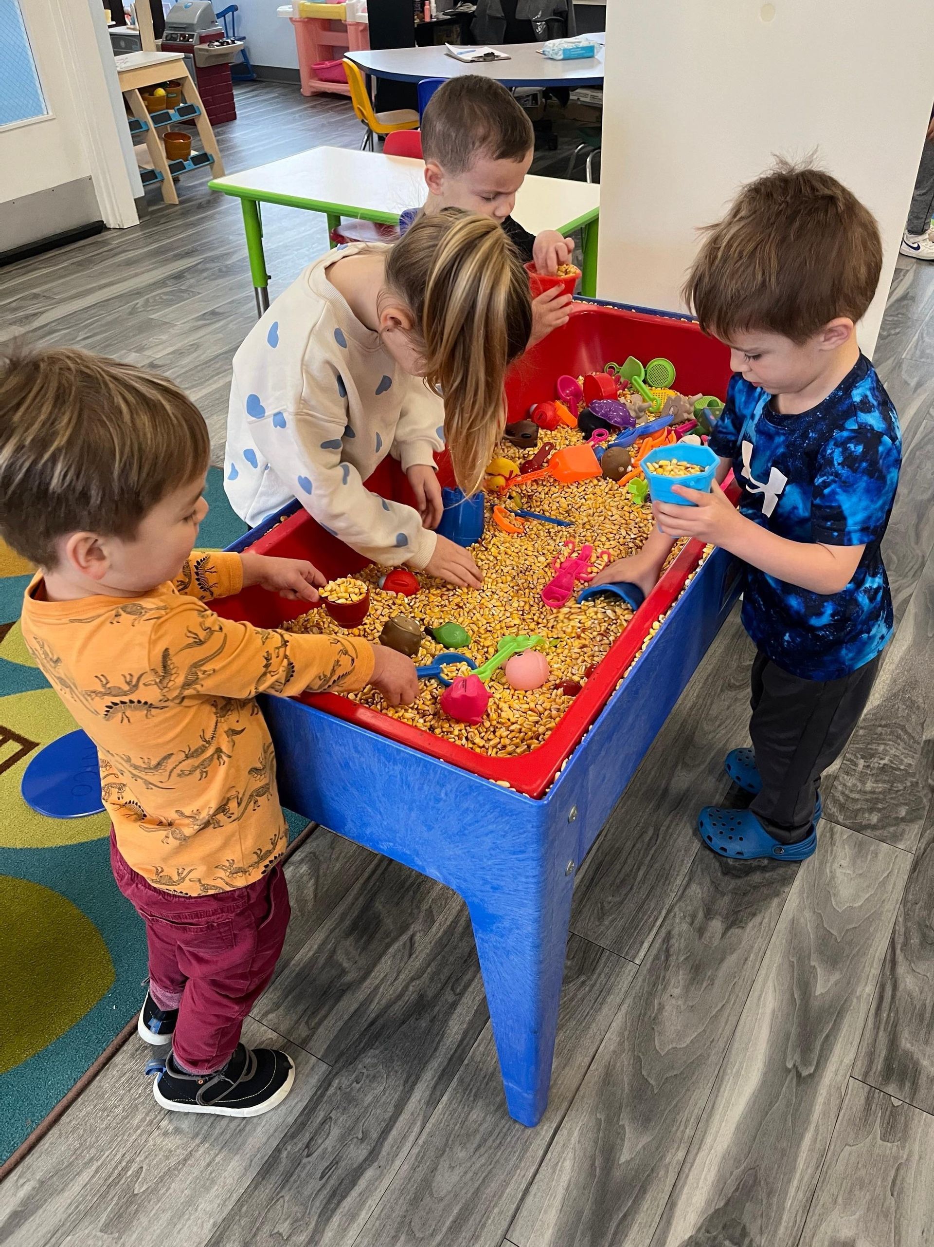 A group of children are playing with sand on a table.