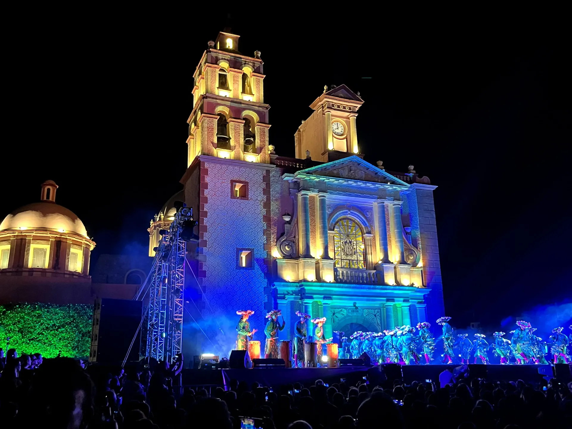 Illuminated historic church at night, glowing blue and gold against a dark sky.
