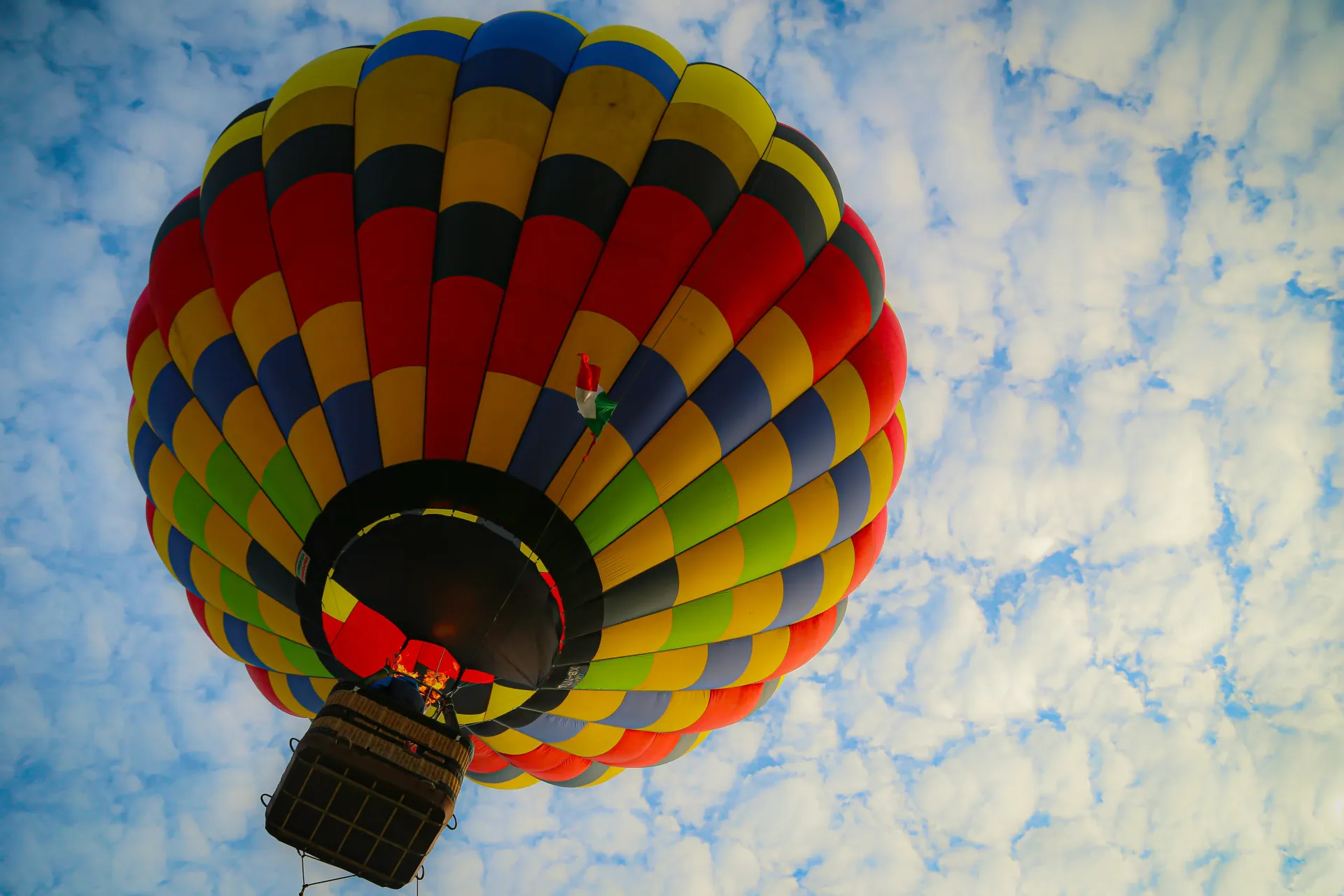 Colorful hot air balloon floating against a cloudy blue sky