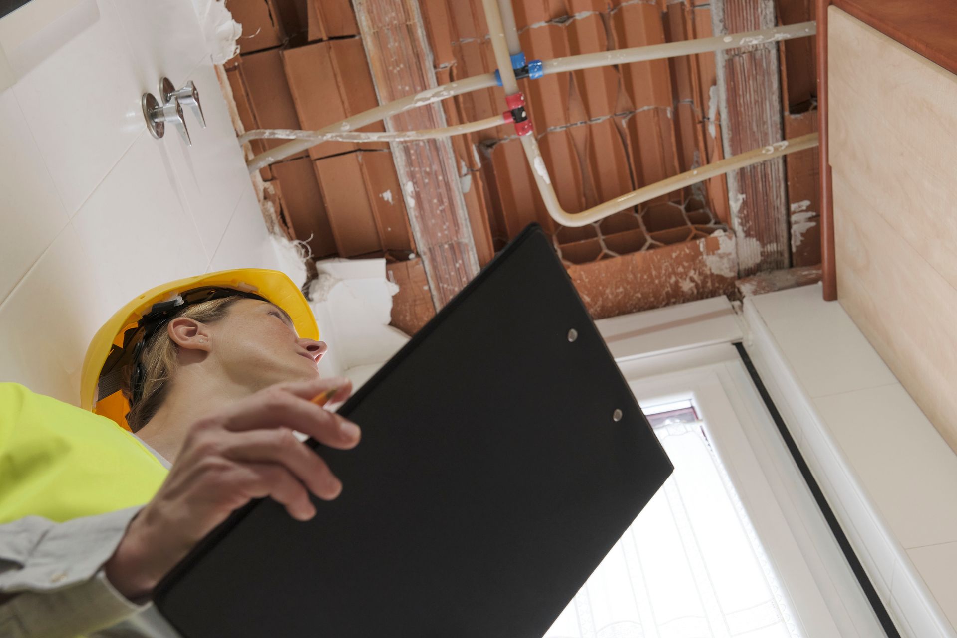 Engineer inspects the wooden roof structure of a house without insulation. Engineer inspects the wooden roof structure of a house without insulation.