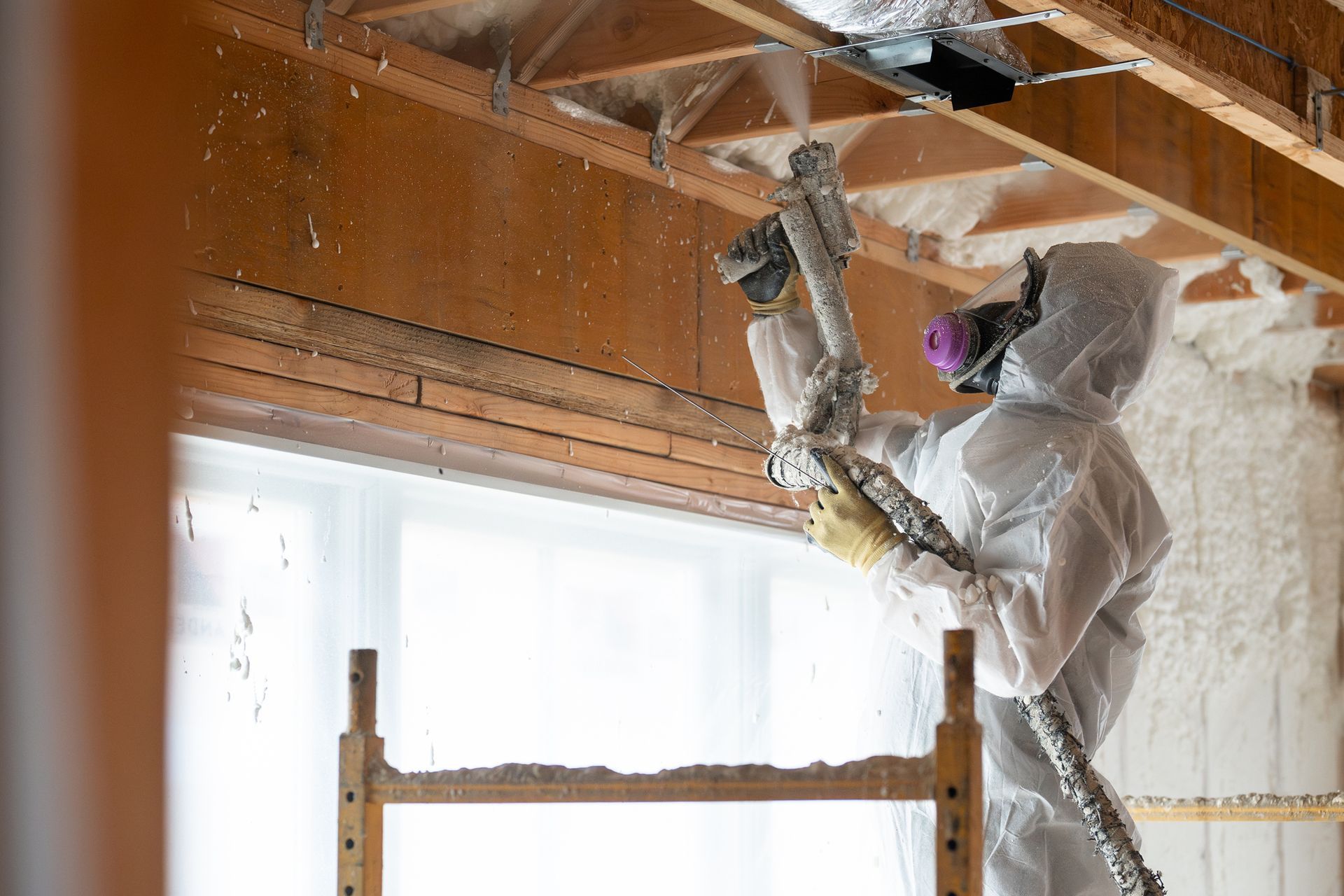 Technician expertly installing ceiling insulation at a residential property.