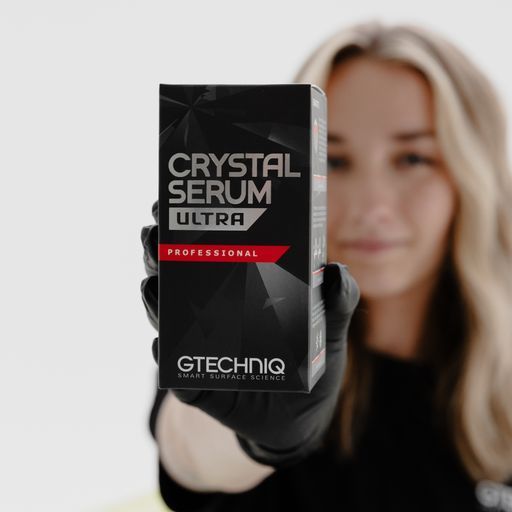 Woman holding a black box of Gtechniq Crystal Serum Ultra car polish.
