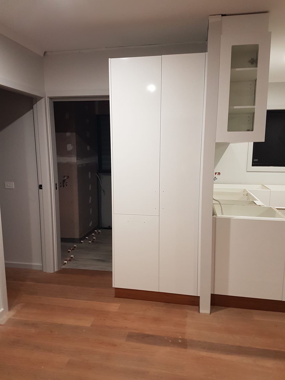 A Kitchen With White Cabinets And A Wooden Floor — Damn Fine Constructions In Coffs Harbour, NSW