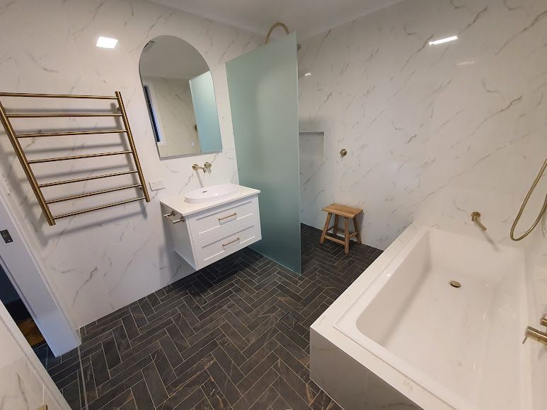A Bathroom With A Bathtub, Sink, Mirror And Walk In Shower — Damn Fine Constructions In Toormina, NSW
