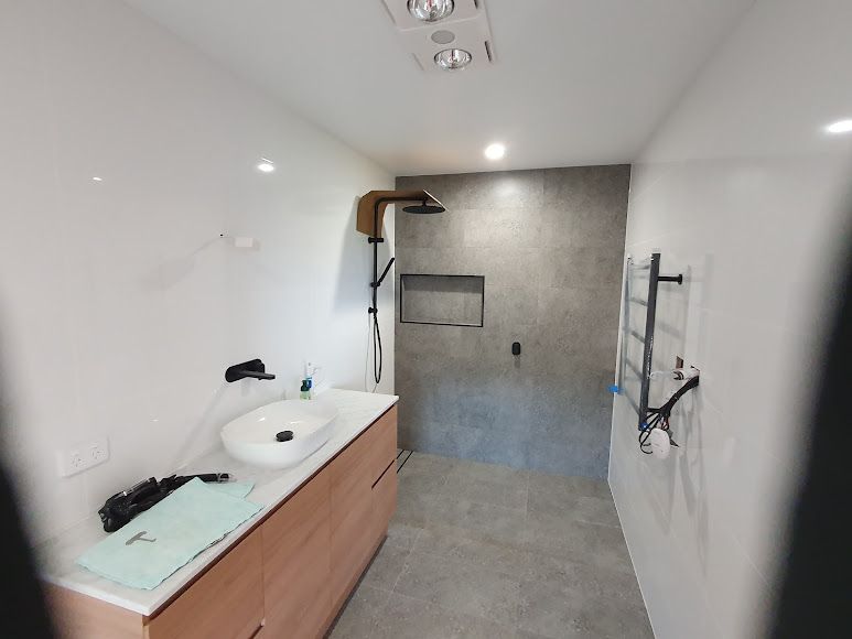 A Bathroom With A Sink, Shower, And Towel Rack — Damn Fine Constructions In Sawtell, NSW