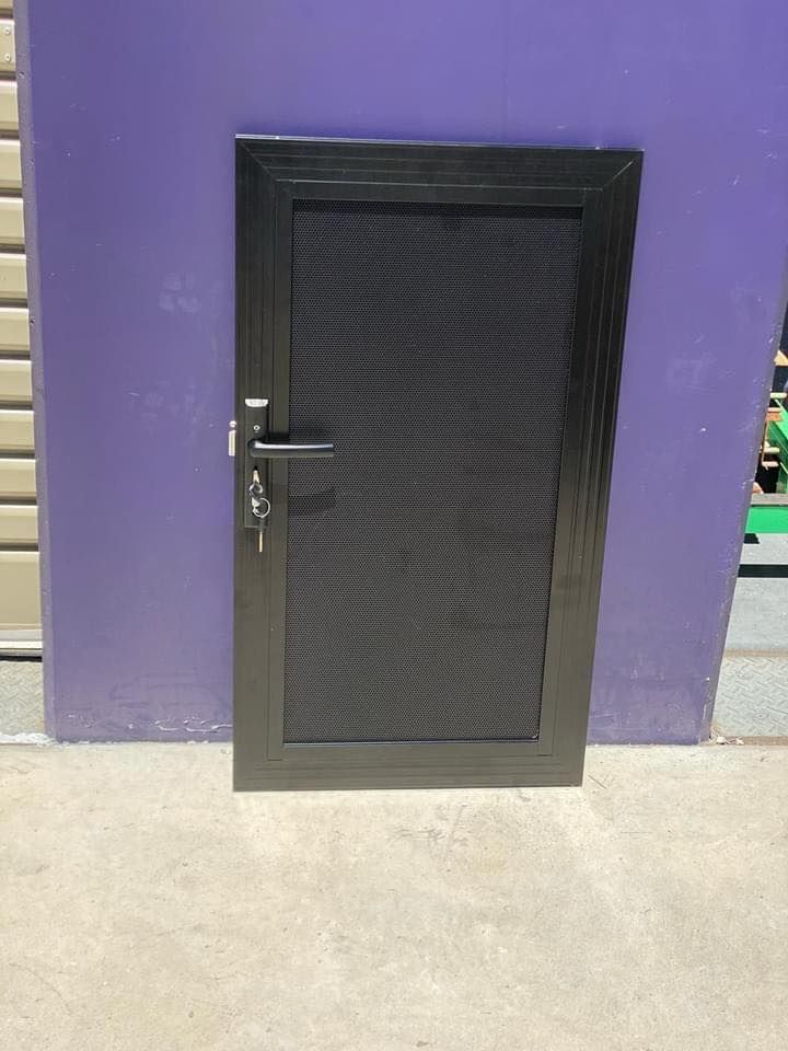 A Black Door Is Sitting in Front of A Purple Wall — Southside Aluminium Windows and Doors in Yallah,